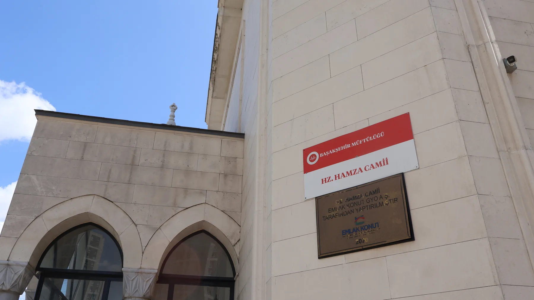 The Başakşehir Müftülüğü sign on the north wall reads HZ. HAMZA CAMİİ. The brass plaque below records that the building was constructed by Emlak Konut GYO in 2020.